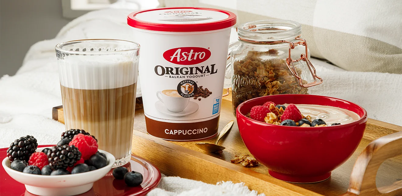 Astro Cappuccino flavoured yogurt tub with a bowl of yogurt, fruit and granola.