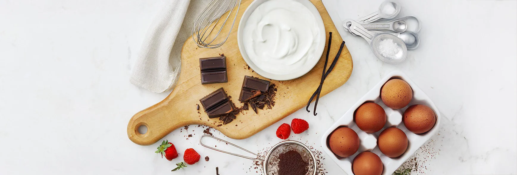 Yogurt, chocolate and eggs on a cutting board