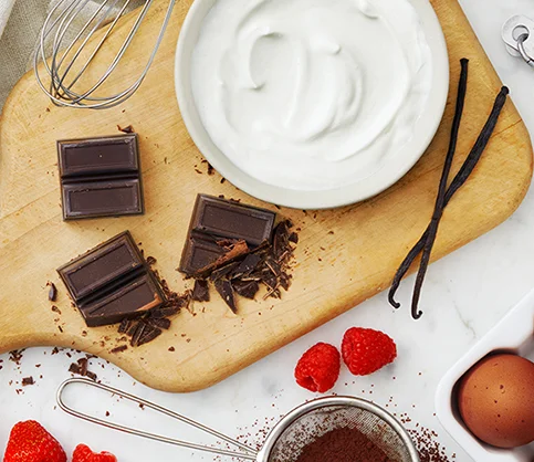 Yogurt, chocolate and eggs on a cutting board